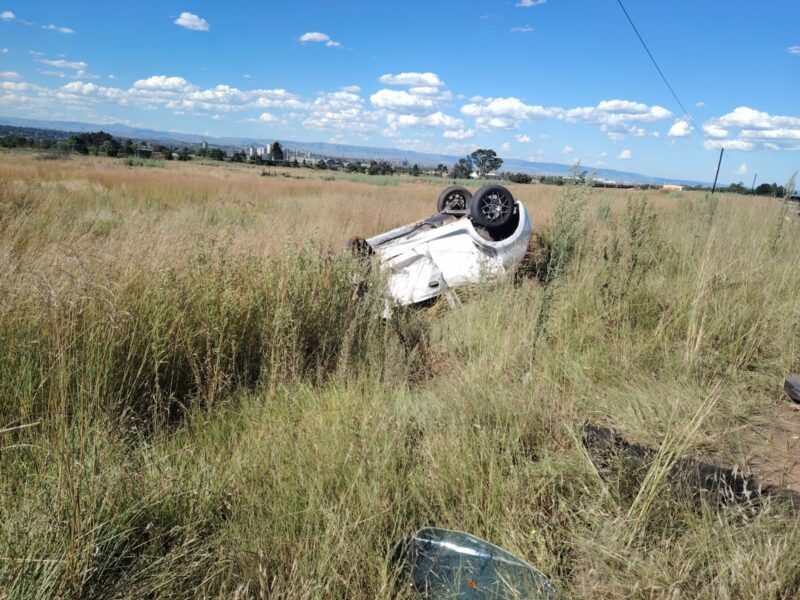 A white vehicle is pictured on its roof after it flipped.