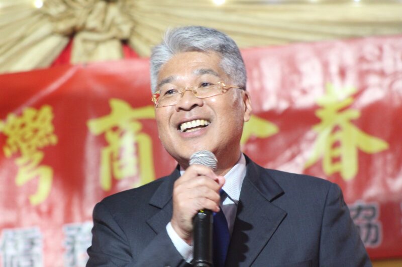One person is photographed in front of a red, gold and yellow Chinese New Year banner during the Taiwanese New Year Celebrations.