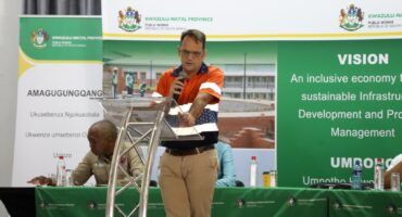 A man addresses a meeting from a podium at a foot-and-mouth disease stakeholder engagement in Newcastle.