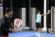 Two players compete during a padel match at night.