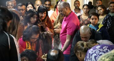 Devotees gather closely inside a temple as they perform Maha Shivaratri rituals and offer prayers.