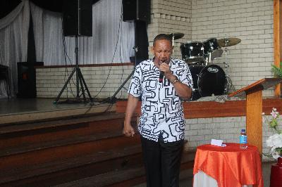 An image of Bishop Derby holding a micro-phone at a prayer service organised by Santaco.