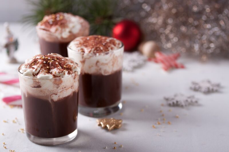 chocolate pudding with whipped cream on a white table setting.