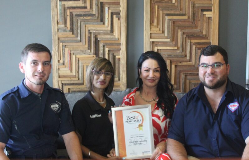 A group of people receiving a certificate from a Caxton Employee.