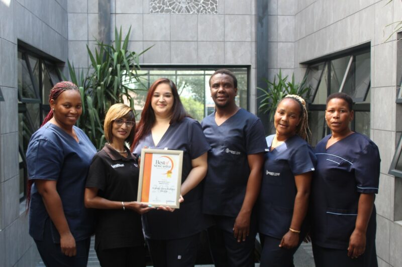 A group of people receiving a certificate from a Caxton Employee.