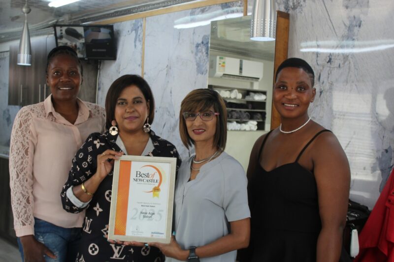 Four people holding an awards certificate for the Best of Newcastle Readers Choice Awards.