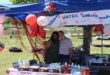 Image of two young girls standing in a stall decorated with Valentine's decor and homemade goods on the table.