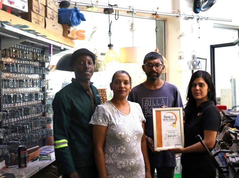A group of people receiving a certificate from a Caxton Employee.