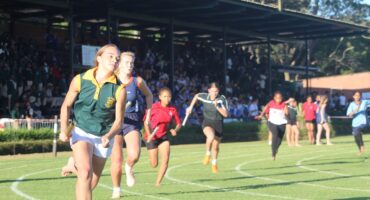 Image of high school athletes setting off in a relay event.
