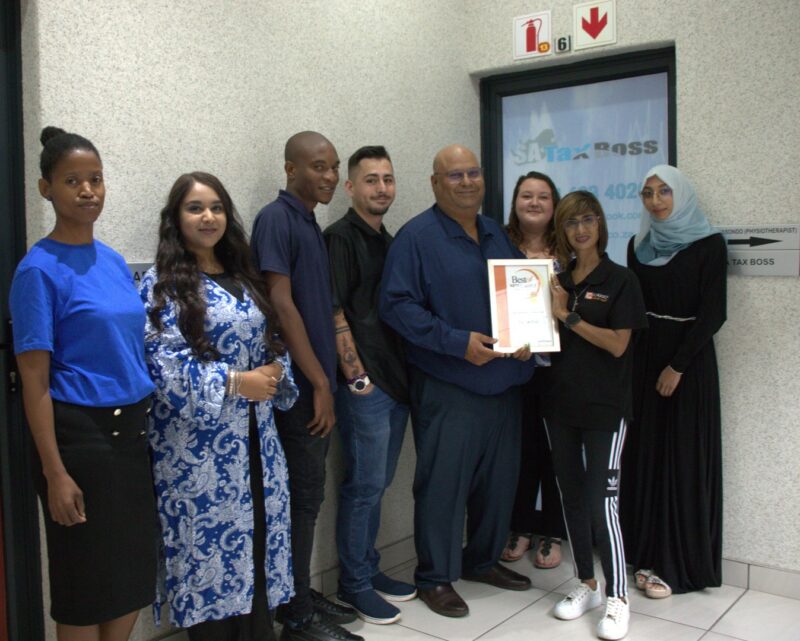 A group of people receiving a certificate from a Caxton Employee.