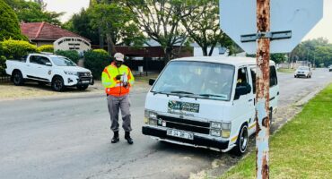 Image of a traffic officer checking a taxi's roadworthiness.
