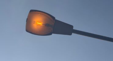 Image of a streetlight that is on during the day.