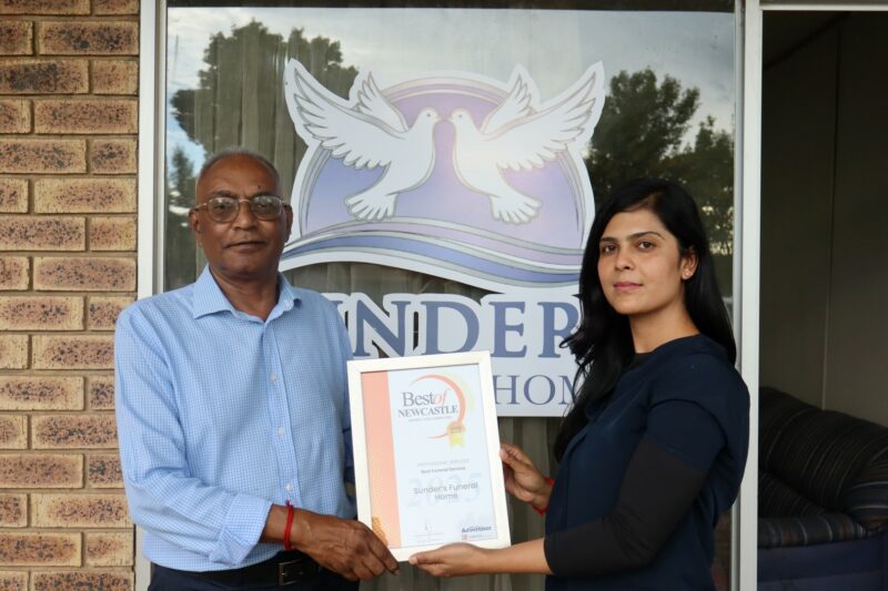 Two people holding an awards certificate for the Best of Newcastle Readers Choice Awards.