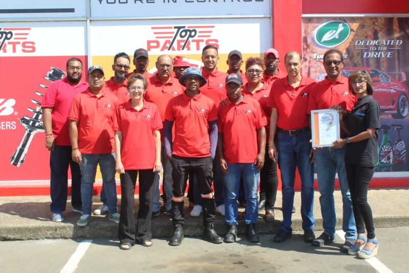 A group of people receiving a certificate from a Caxton Employee.