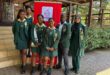 Image of learners from VHS dressed in school uniform standing in front of a SANBS banner.