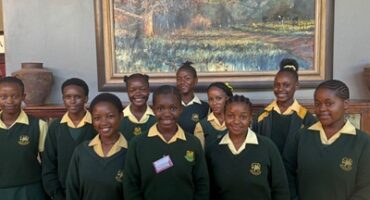 Image of young female learners in yellow and green school uniform from Vryheid High School.