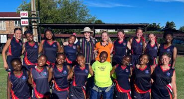 Volksrust High School girls’ hockey team posing together on the field.