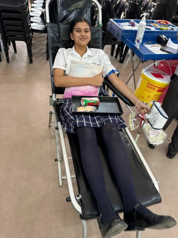 A learner laying in a chair while donating blood at school.