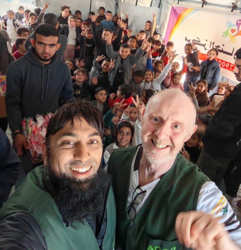 Mahomed Zahir Haniff poses with multiple humanitarians and residents while in Gaza. (Image supplied).