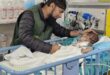 A Newcastle pharmacist is photographed with a young child who was in hospital after being injured in war-torn Gaza.