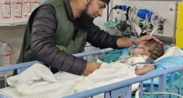A Newcastle pharmacist is photographed with a young child who was in hospital after being injured in war-torn Gaza.