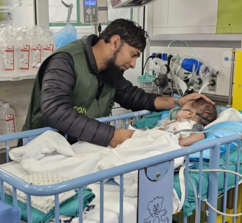 A Newcastle pharmacist is photographed with a young child who was in hospital after being injured in war-torn Gaza.