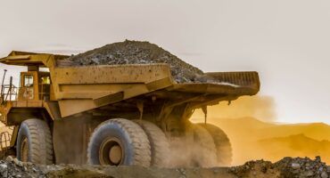 Large mining truck transports coal at an open-cast mine.