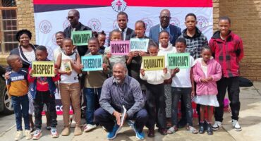 An image of Methodist Church children and AbaQulusi Ward 11 committee member Mr Nxumalo, at the Human Rights Day service held at Mondlo.