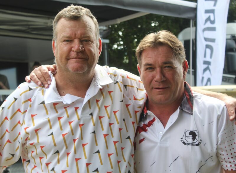 Two golfers posing for a photo at the Newcastle Golf Club wearing their golfing attire.