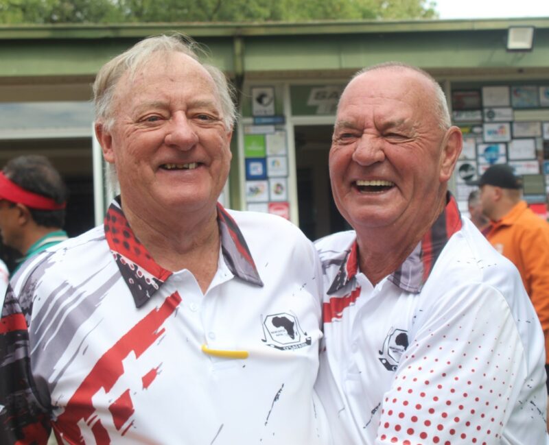 Two golfers posing for a photo at the Newcastle Golf Club wearing their golfing attire.