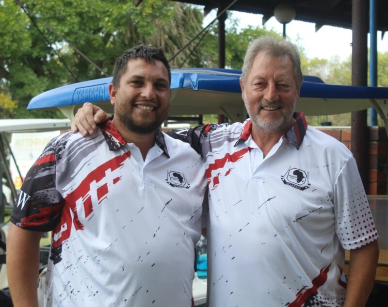 Two golfers posing for a photo at the Newcastle Golf Club wearing their golfing attire.