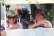 Two golfers posing for a photo in a golf cart at the Newcastle Golf Club.