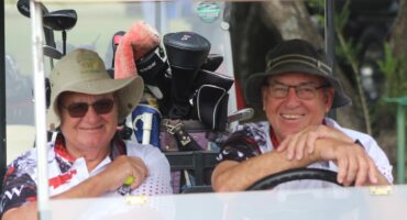 Two golfers posing for a photo in a golf cart at the Newcastle Golf Club.