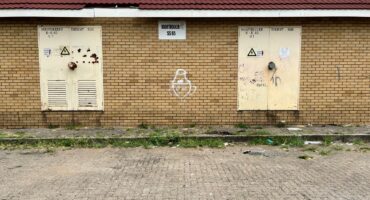 Exterior of Voortrekker SS65 substation with graffiti and damaged doors.