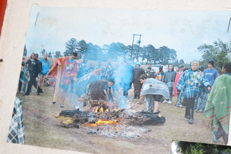 Scouts gather around a campfire during an outdoor ceremony