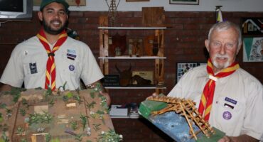 Two Scout leaders display handmade campsite and bridge models