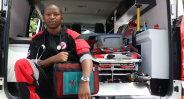 Sakhile Nkosi in the ambulance at Magenta Security Services in Newcastle. He is sitting with medical supplies on his lap, as well as a stetascope around his neck.