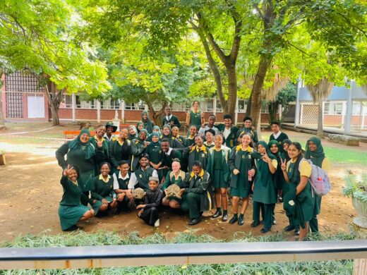 Image of learners in green and yellow uniforms with a tortoise.