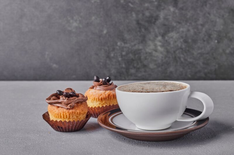 Cupcakes with chocolate cream served with a cup of coffee.