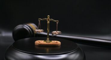 Scales of justice on a gavel in a courtroom setting