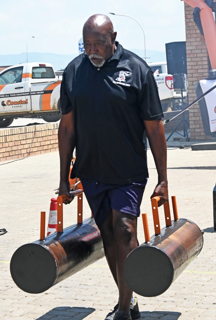 A photo of a man participating in a strong man competition at the Newcastle Coastal Hire New Store launch.