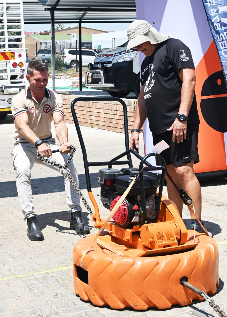 A photo of a man participating in a strong man competition at the Newcastle Coastal Hire New Store launch.