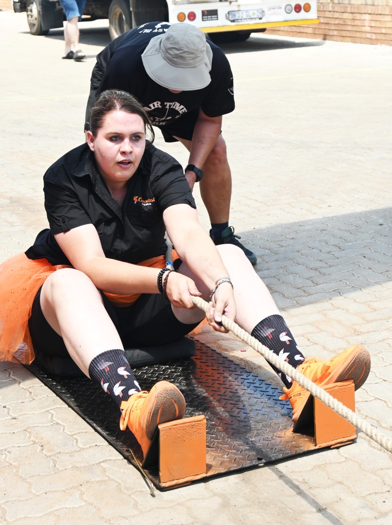 A photo of a woman participating in a strong man competition at the Newcastle Coastal Hire New Store launch.