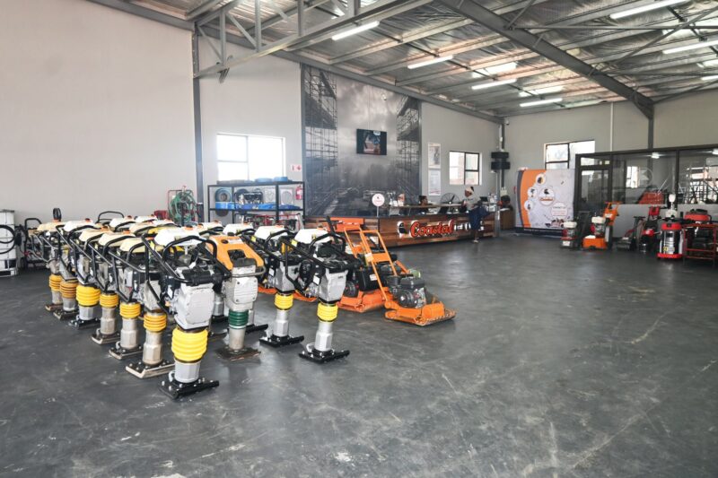 A photo of a business workshop filled with heavy machinery tools and vehicles.
