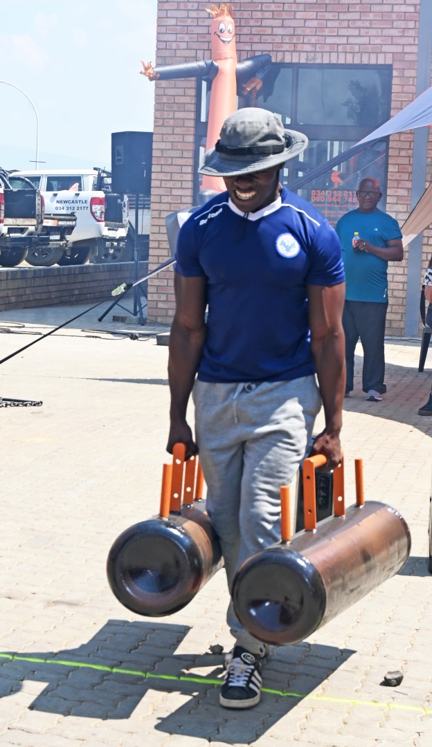 A photo of a man participating in a strong man competition at the Newcastle Coastal Hire New Store launch.