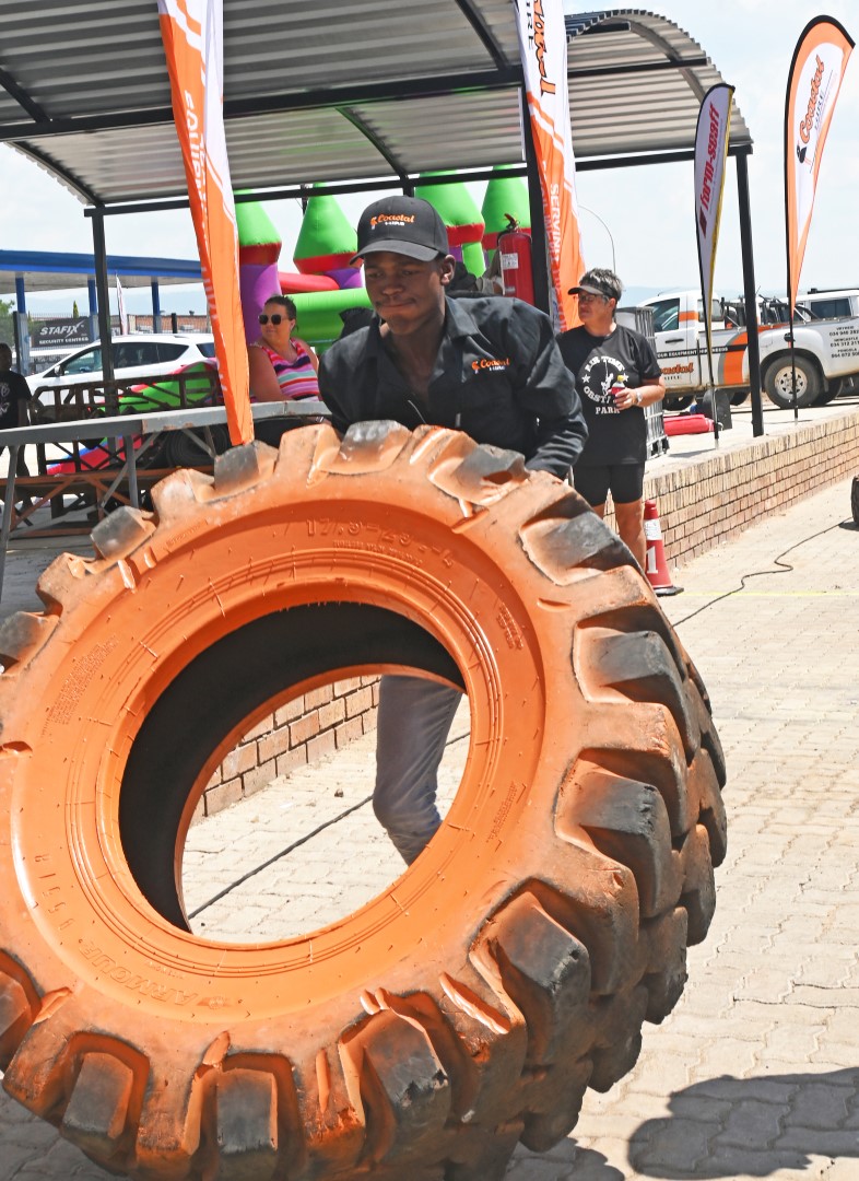 A photo of a man participating in a strong man competition at the Newcastle Coastal Hire New Store launch.
