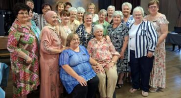 Group of women pose together at indoor community gathering