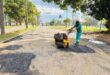 An image of a municipal worker holding a machine, patching potholes in one of the streets in the Vryheid CBD.