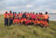 A large group of anglers pose for a photo in front of the Chelmsford Dam.