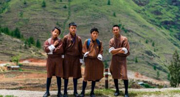 Shool boys in Bhutan, wearing their school uniform, which is the Gho (the traditional dress for men).